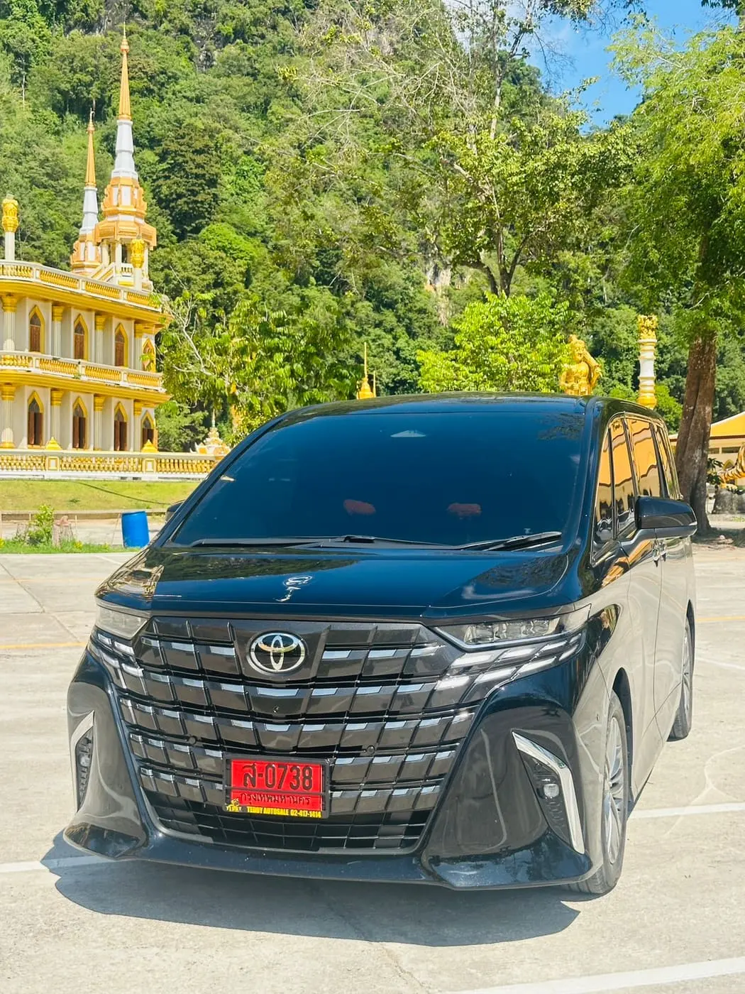 Toyota Alphard สีดำ มุมด้านหน้า จอดที่วัดในภาคใต้